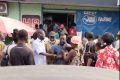 Le 2e adjoint au maire de Franceville, Jules Ferry Ndoumou,  sortant du magasin, hagard, titubant et abasourdi, soutenu par la population. © Capture d’écran/Gabonreview