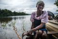 Pêcheur nettoyant et cuisinant du poisson sur le lac Oguemoué. © Roshni Lodhia