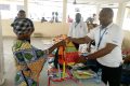 Fabrice Armel Makouaza remettant les kits scolaires à un parent d’élève. © Gabonreview