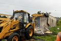 Un engin de Afcons démolissant les maisons situées sur le tracée de la voie de
contournement de l’aéroport, le 6 décembre 2022. © Gabonreview