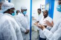 Raymond Ndong Sima suivant les explications lors de sa visite des installations de La Santé Pharmaceutique SA. © D.R.